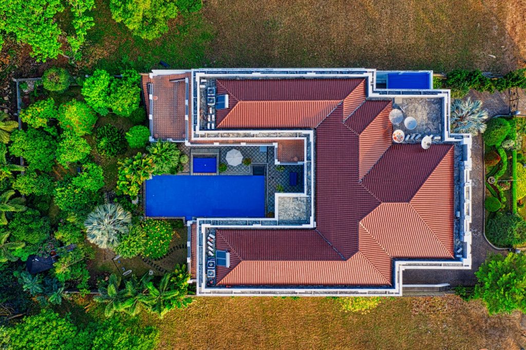 Aerial view of house with garden and pool.