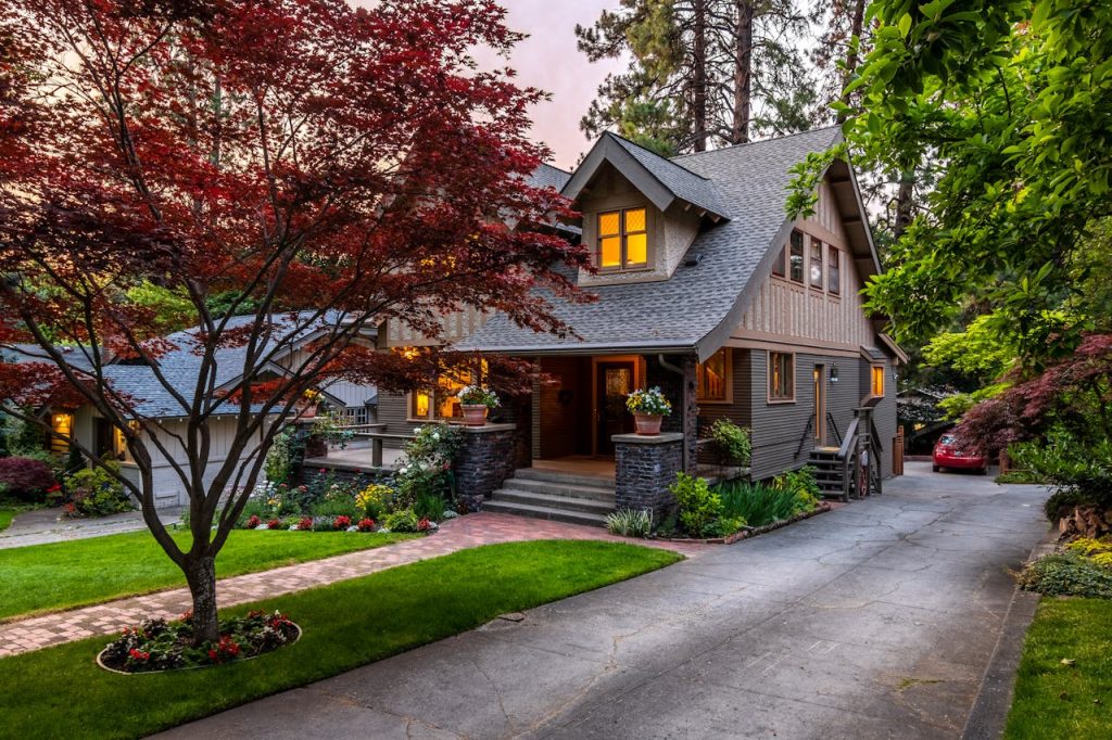Charming craftsman house with landscaped yard at sunset.
