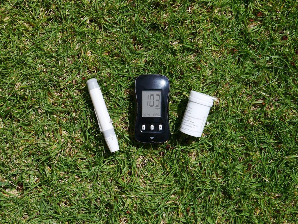 Blood glucose meter and supplies on grass